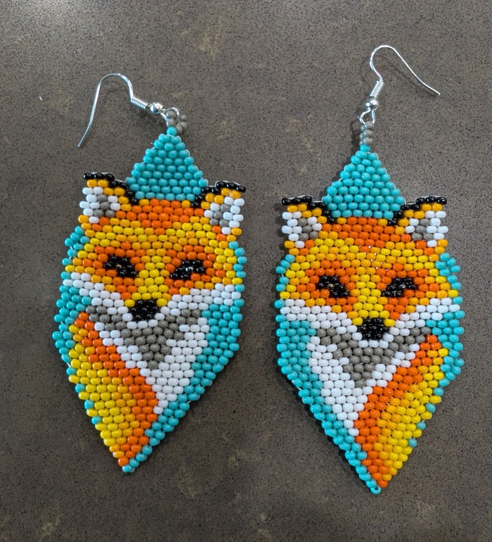 Beaded fox-shaped earrings on a gray surface