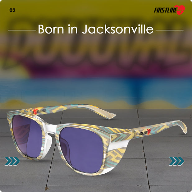 Firstline Duval Fade Jacksonville safety goggles with photochromic lenses and colorful frame, displayed on a gray surface with the 'Duuuval' mural in the background