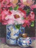 Still life painting of pink flowers in a blue and white vase with a small decorative object.