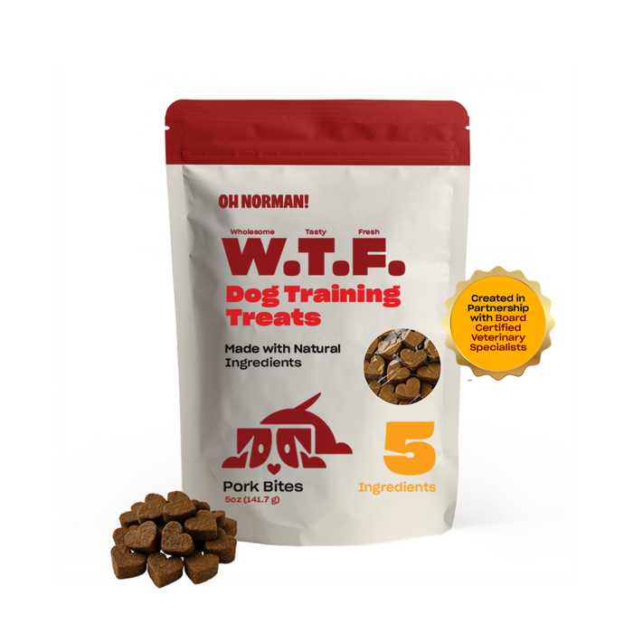 Front view of W.T.F. Dog Training Treats pouch showing red resealable bag, pile of heart-shaped pork bites, '5 Ingredients' text and gold veterinary-certified seal on white background